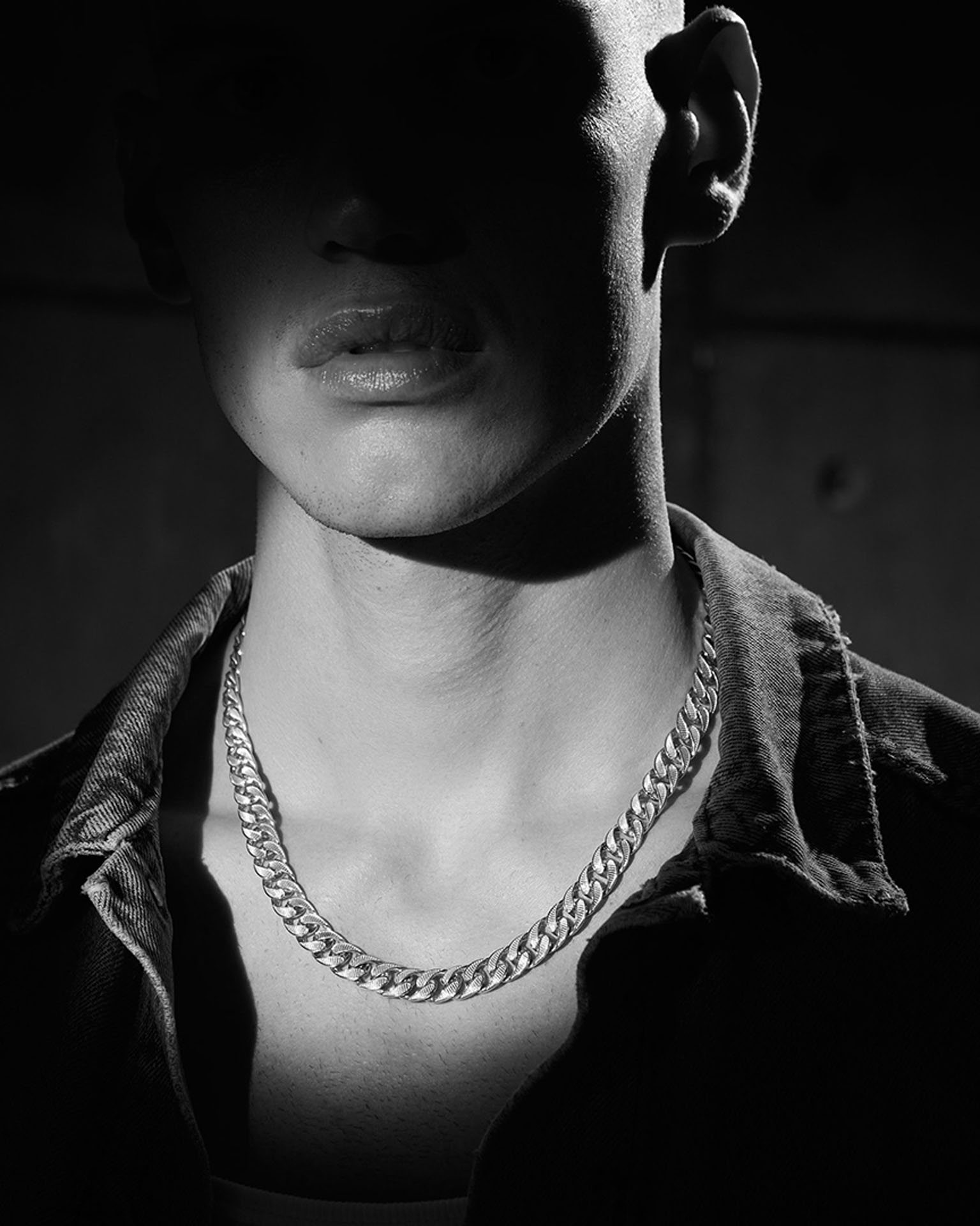 Model Noah Gamma portrayed by David Hatters for Zancan Gioielli. A strong black and white photo with a light spot on the neck to enlighten the necklace jewel.
